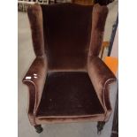 Brown upholstered wing back armchair.