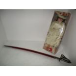 A reproduction cutlass in scabbard and a boxed doll 'Angelique'
