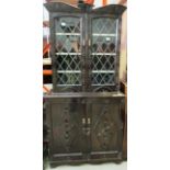 A carved oak wall unit with 2 upper leaded glazed doors over 2 base doors 95 x 195cm high
