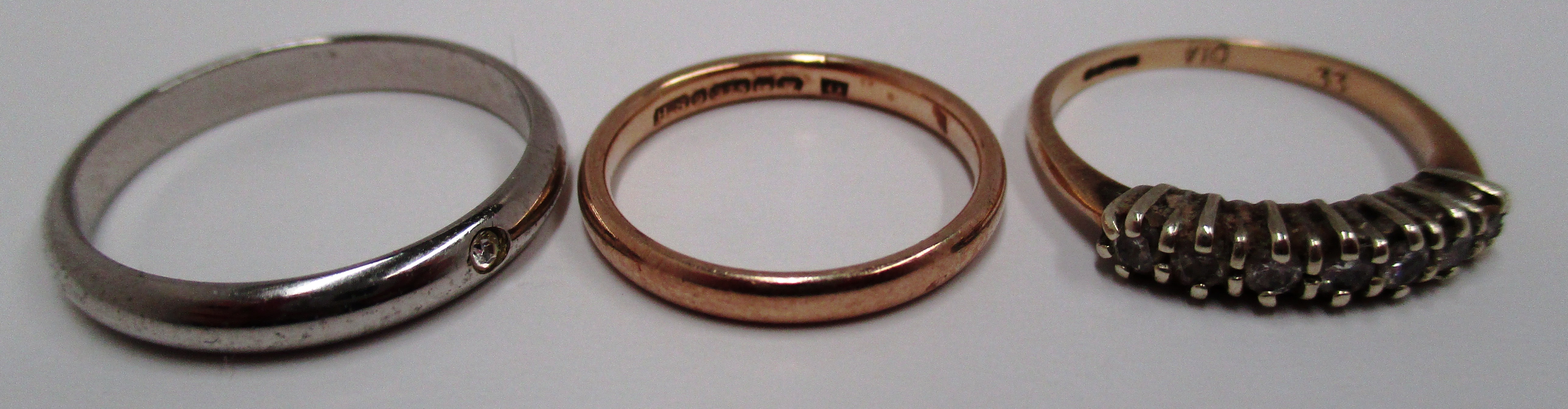 9ct yellow gold wedding band 1.9g, one unmarked ring and a 9ct yellow gold seven stone ring 1.
