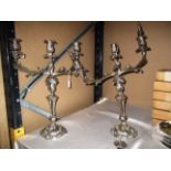 A pair of ornate plated candelabra,