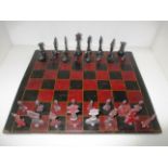 A miniature lead chess set complete with wooden chess board