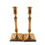 A pair of 18th Century Brass candlesticks with fluted square stems, wide square bases and detachable
