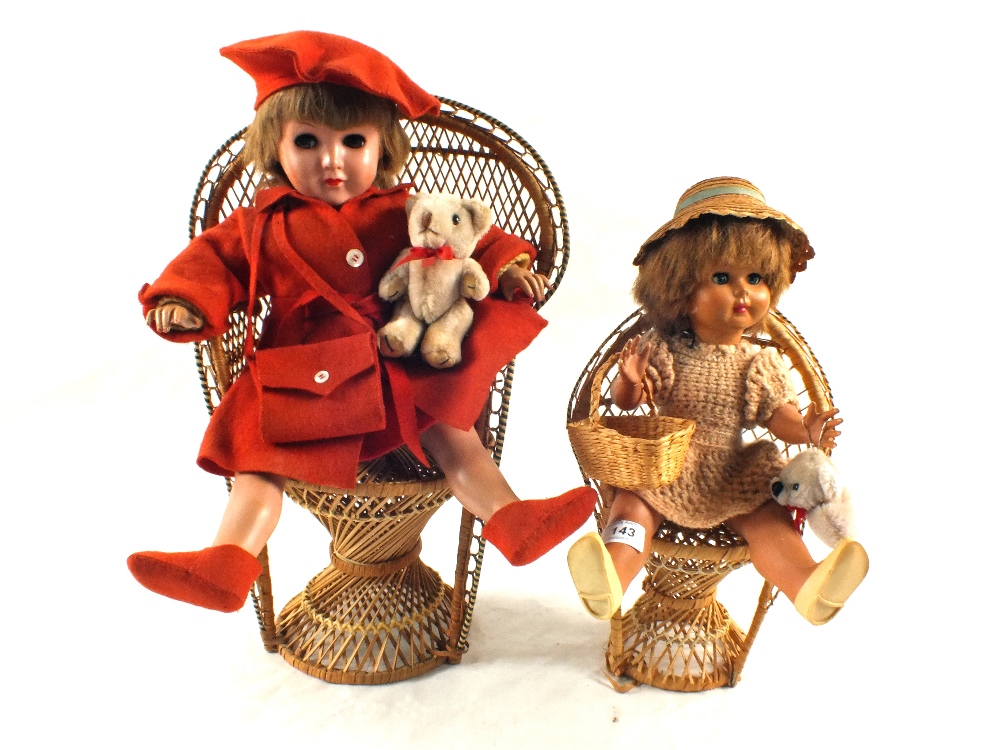 A pair of dolls on wicker chairs,