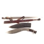 A kukri in its sheath with an ethnic short sword in leather scabbard