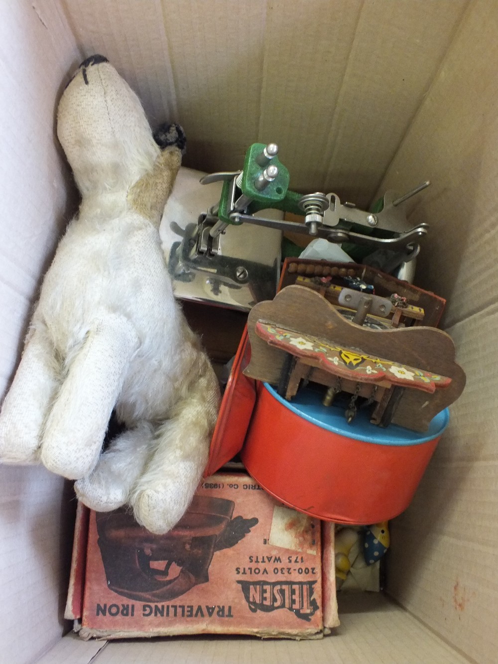 A childs sewing machine, travelling iron and a stuffed dog,