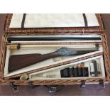 A wicker gun basket, fitted to hold a shotgun, containing a cleaning kit, hip flask,