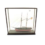 A cased wooden two masted sailboat