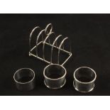 A Silver toast rack and three serviette rings