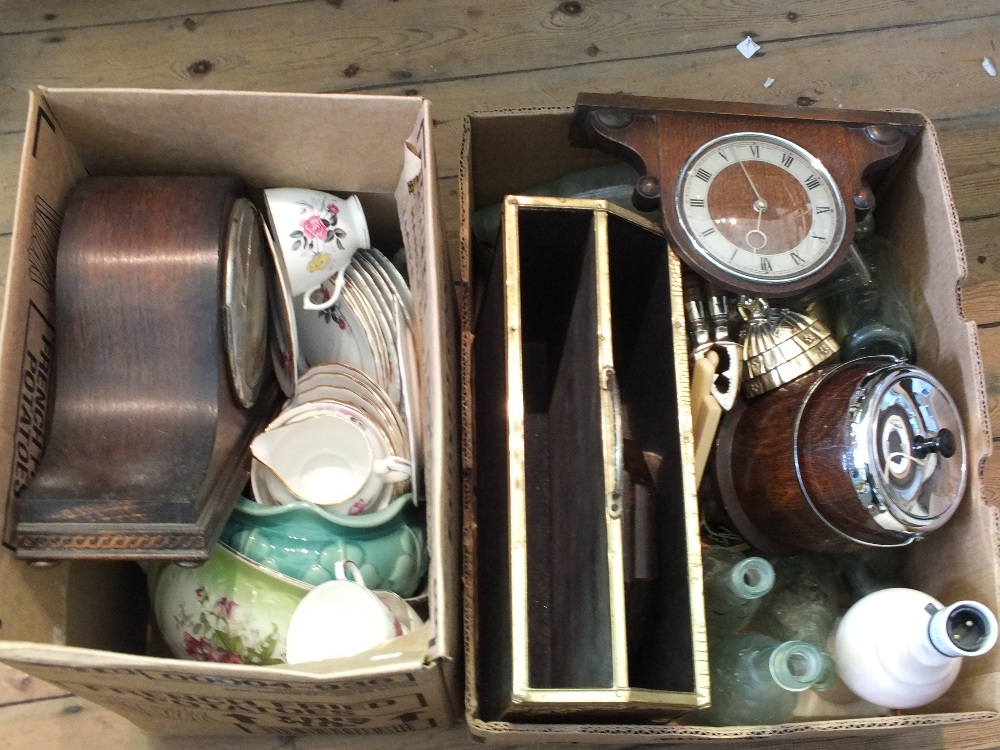 A Brass magazine rack, two clocks, bottles, glass,