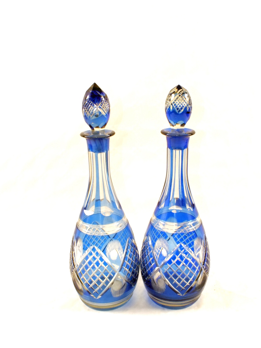 A pair of blue overlaid cut glass decanters