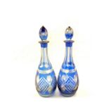 A pair of blue overlaid cut glass decanters