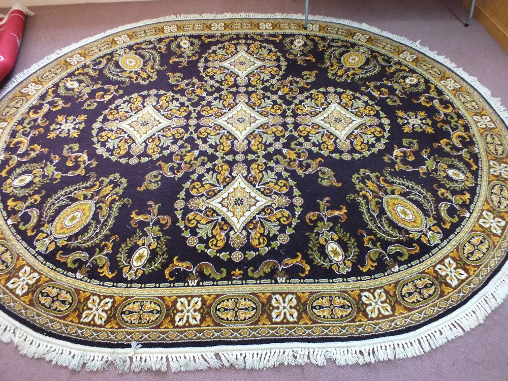 An oval mauve ground floral Axminster carpet,