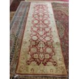 A Pakistan red ground floral runner, 119" x 36"