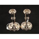 A Silver tea strainer, London 1928 and a pair of Silver candlesticks,