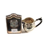 A Silver mounted timepiece with white metal jug