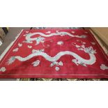 A Chinese red ground carpet with two dragon decoration,