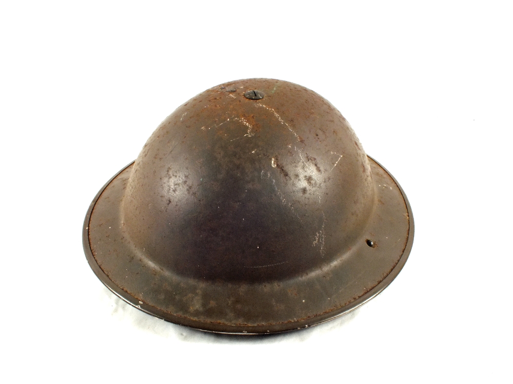 A tin helmet with nine volumes of 'The Great War'