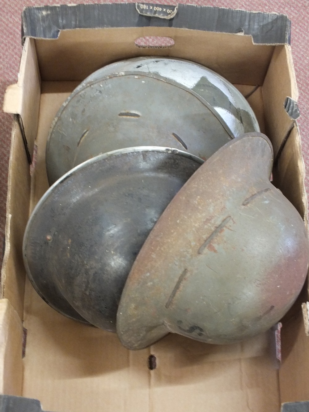 A collection of six WWII era British helmets