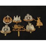 Seven cap badges including Suffolk,