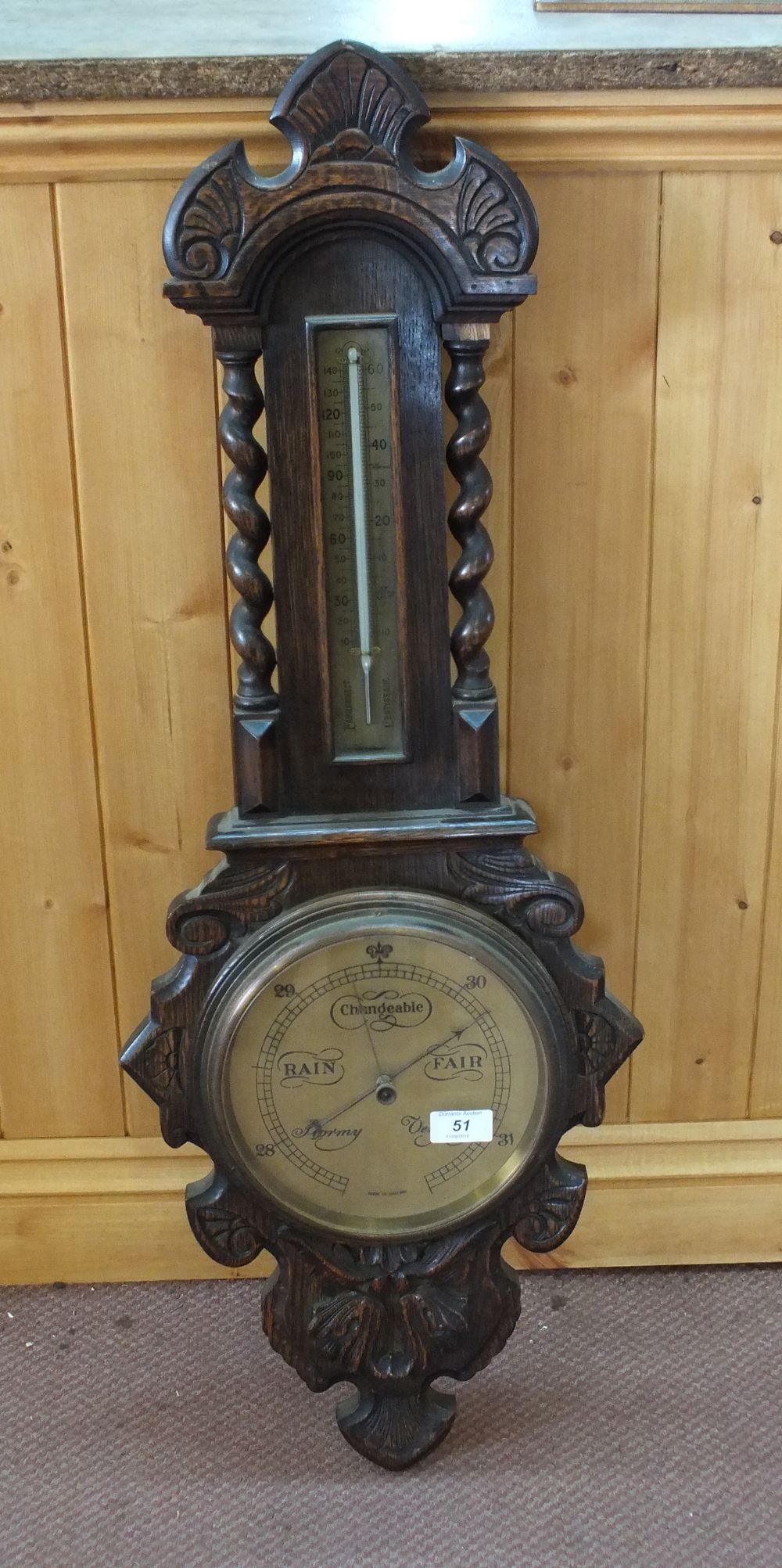 A carved Oak banjo barometer with Brass dial