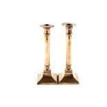 A pair of Georgian Brass or gun metal candlesticks on square bases, each stamped '11',