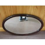 An oval Mahogany wall mirror