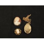 A large Gold plated foliate engraved locket on chain with a Gold plated cameo brooch and a white