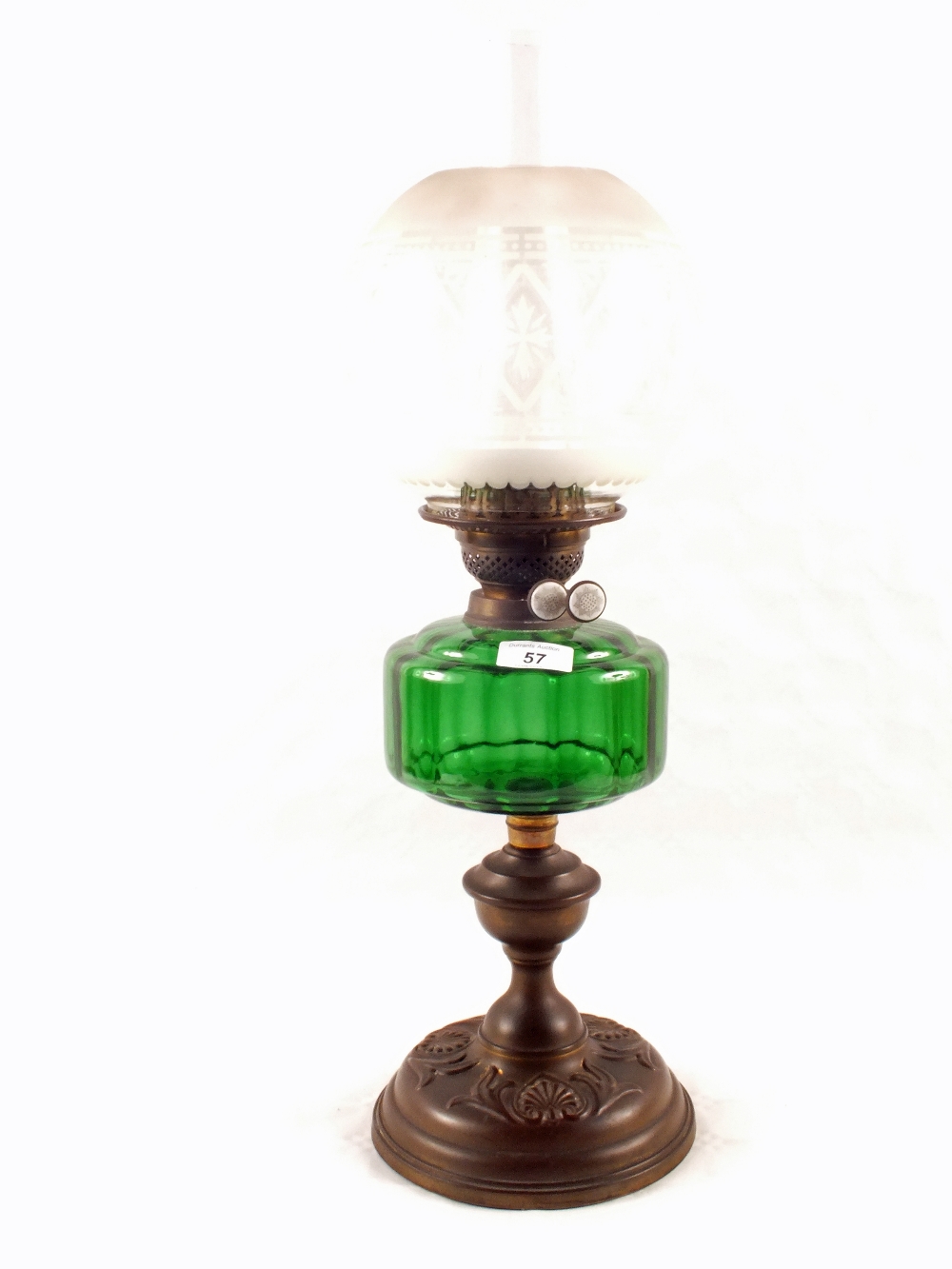 An embossed Brass oil lamp with green glass bowl and etched globe