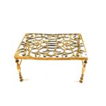 A 19th Century rectangular pierced Brass trivet on turned legs,