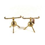 A pair of Arts and Crafts Christopher Dresser design globular Brass fire dogs on tripod feet