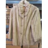 A lady's brown fur jacket and various furs