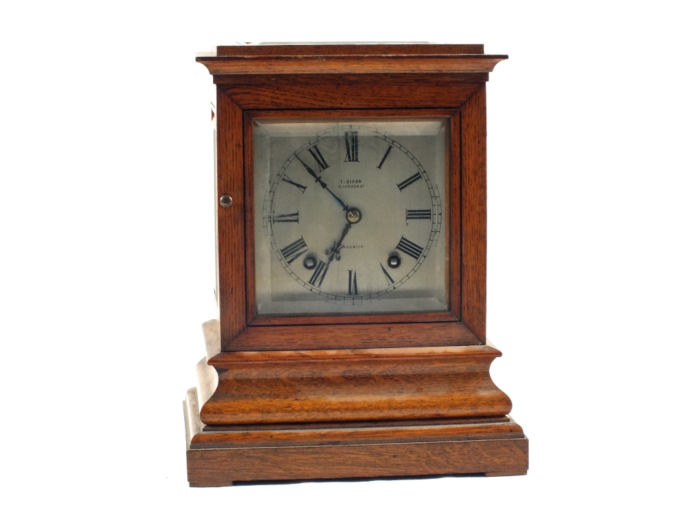 An Oak striking mantel clock with bevelled glass sides, dial marked T.