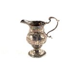 A Silver cream jug with dog, hare and house embossed decoration,