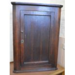 An Oak hanging corner cupboard