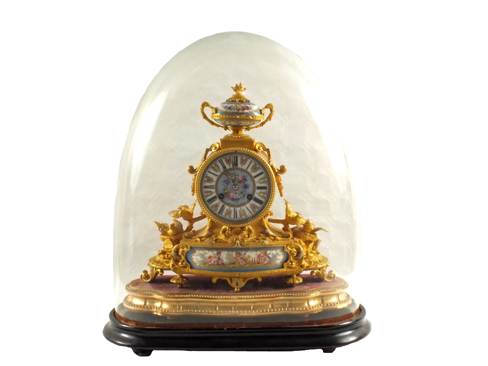 A 19th Century French Ormolu mantel clock under a glass dome with floral Sevres type porcelain urn