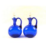 A pair of 19th Century blue glass claret jugs (replacement stoppers)