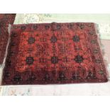 A Persian red ground floral rug,