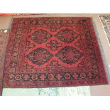 A Persian red ground floral rug,