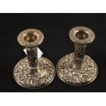 A pair of Silver bird decorated candlesticks,