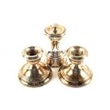 A pair of squat Silver candlesticks and a pepper grinder