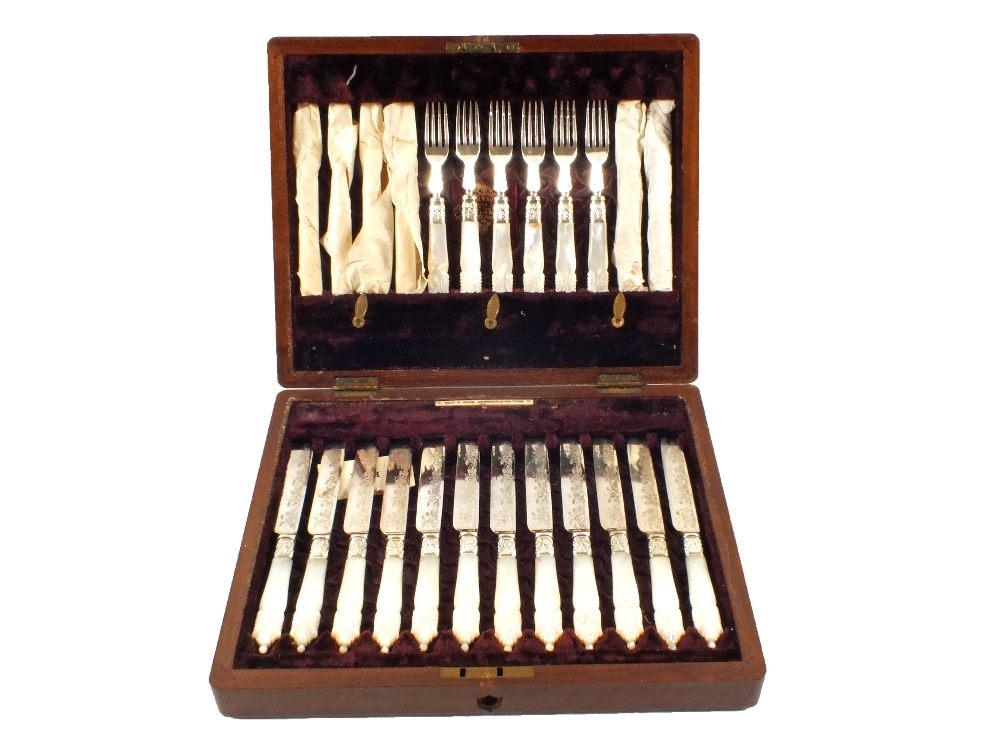 A Mahogany canteen of twenty four Silver plated and Mother of Pearl tea knives and forks