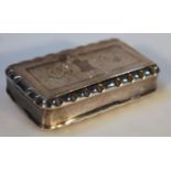 An early 19thC snuff box, of shaped rectangular form with a stylized gadrooned border, the hinged