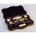 An Edwardian necessaire, the pressed leather purple case, hinging to reveal various implements,