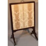 An Edwardian mahogany articulated fire screen, with adjustable central section centred by a brass