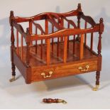 A Regency style mahogany finish Canterbury, the upper carved section raised on baluster columns,