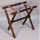 An oak luggage rack, of 'X' framed articulated form, with cylindrical bamboo finish supports and