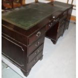 A mahogany finish twin pedestal writing desk, the one piece part stencilled leatherette top raised