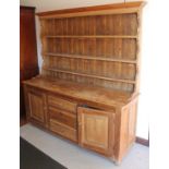A 19thC pine and light oak dresser, the upper section with a fixed moulded cornice, raised above