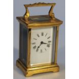 An early 20thC French carriage clock, the rectangular brass case with four sided glazed panels,